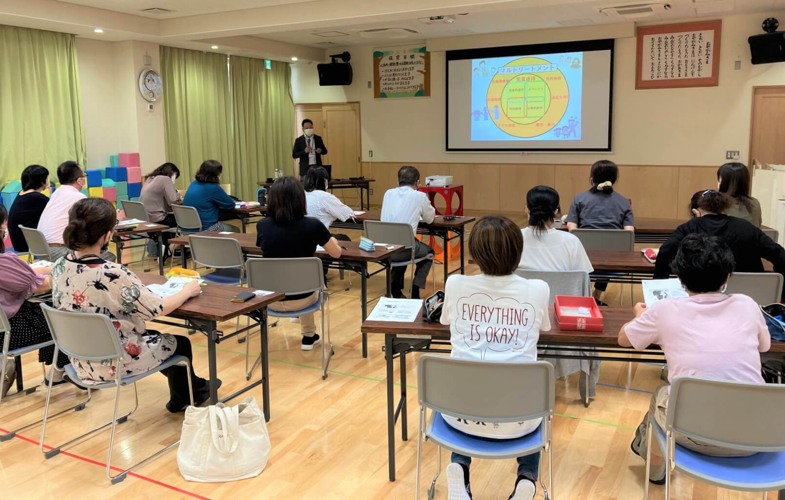 イライラしない子育て講座の開催風景1 - 講師がスクリーンを使って参加者に説明している様子